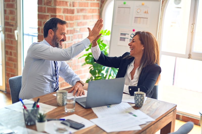 A diverse team of professionals having a dynamic video conference call on a large screen, showing collaboration across different time zones